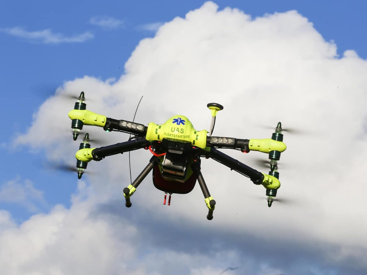 AED-carrying delivery drone in flight against a clear sky, captured during operational trials by the Karolinska Institutet drone programme.